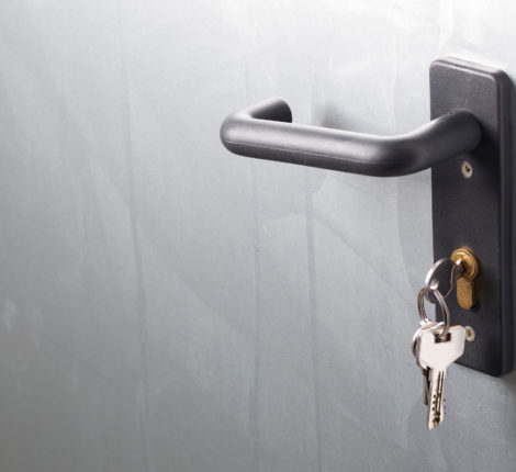 A door handle with lock and keys. The door is metallic.